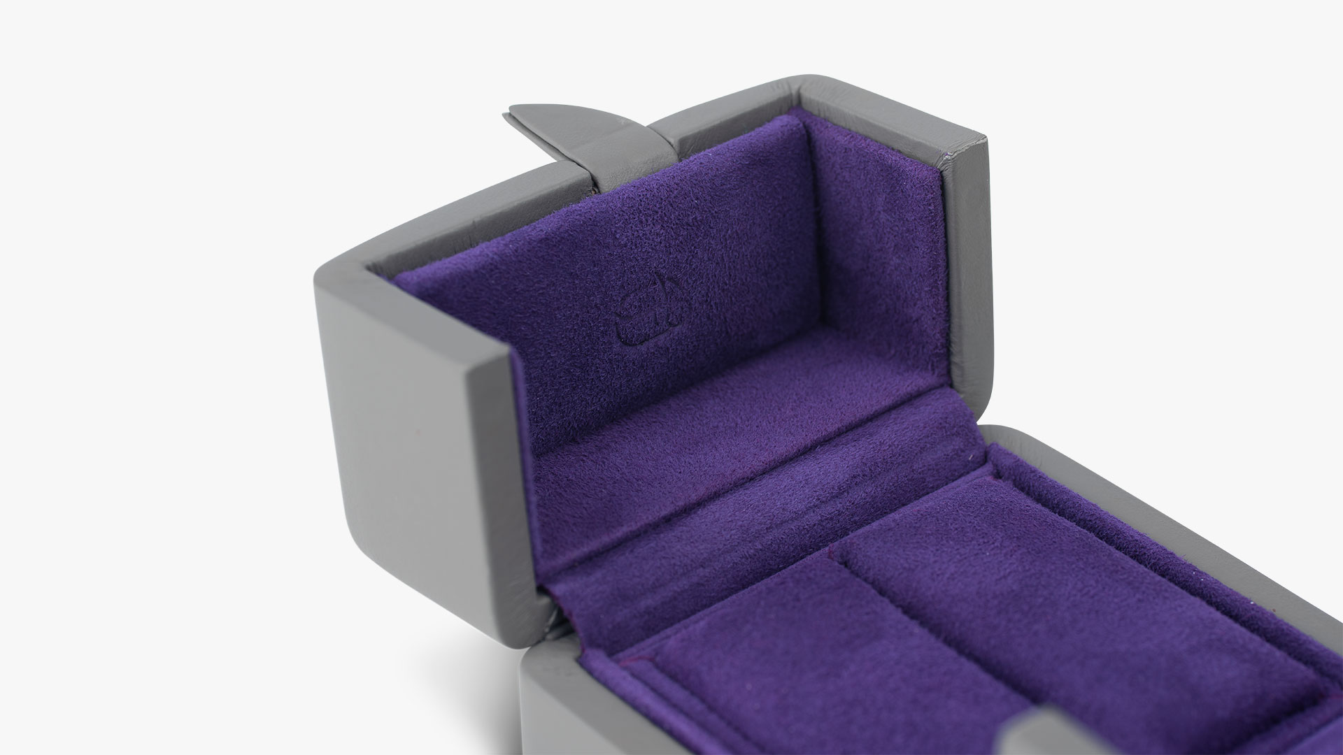 Nahaufnahme eines Ring-Etuis mit Ringbäckchen der Serie Versailles mit Außenfarbe Grey Brown und Innenfarbe Prune.