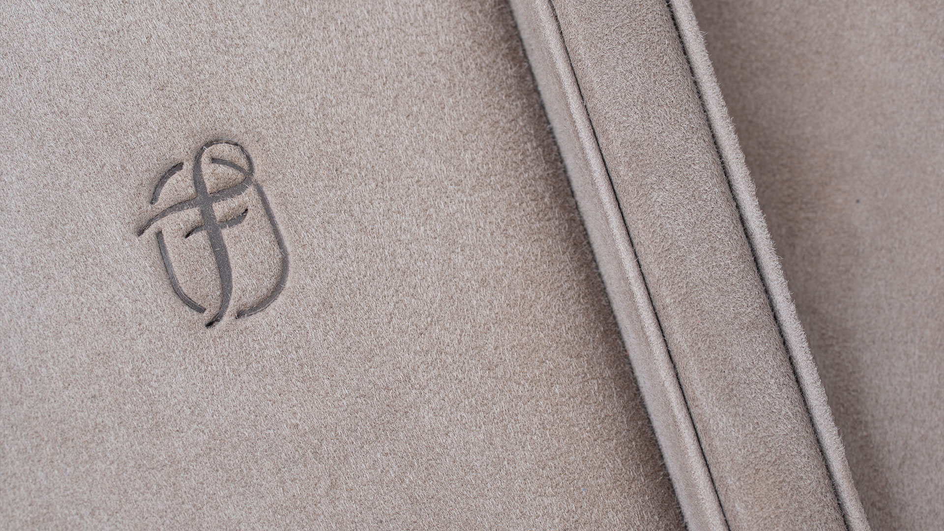 Nahaufnahme der Fleur de Luxe Prägung Innen auf dem Veloursleder in der Farbe Gris Perle.