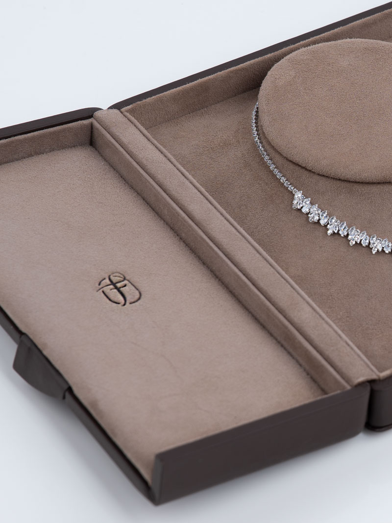 Détail d'un écrin à colliers en cuir véritable dans les couleurs Terra-Tabacco avec logo en relief à l'intérieur du couvercle gauche