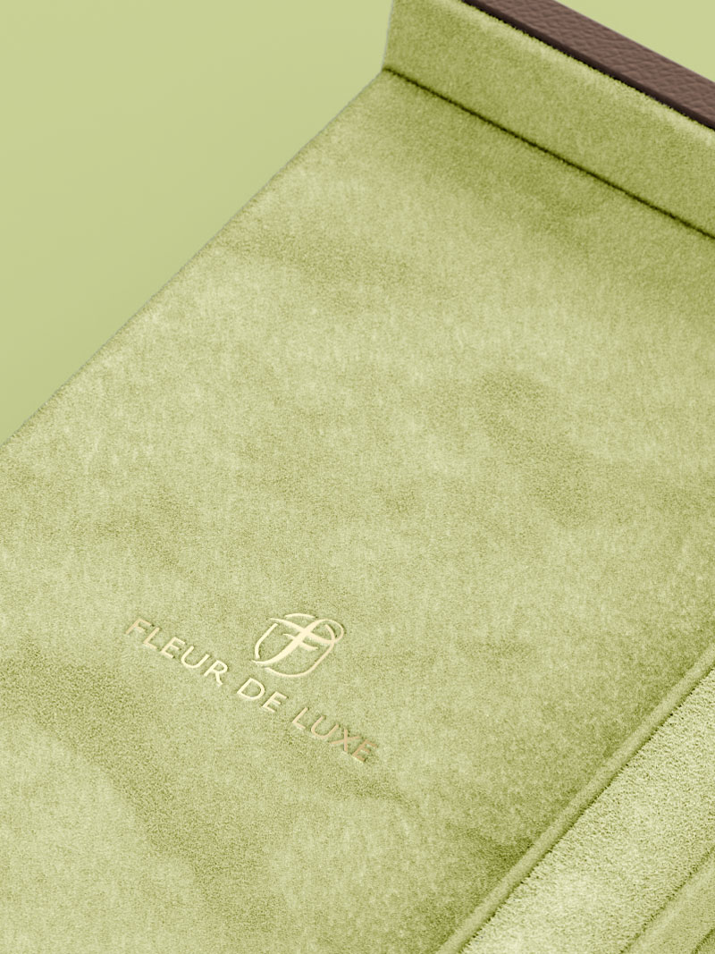 Détail intérieur du couvercle d'un écrin à collier Fleur de Luxe en couleur pistache avec logo en dorure à chaud
