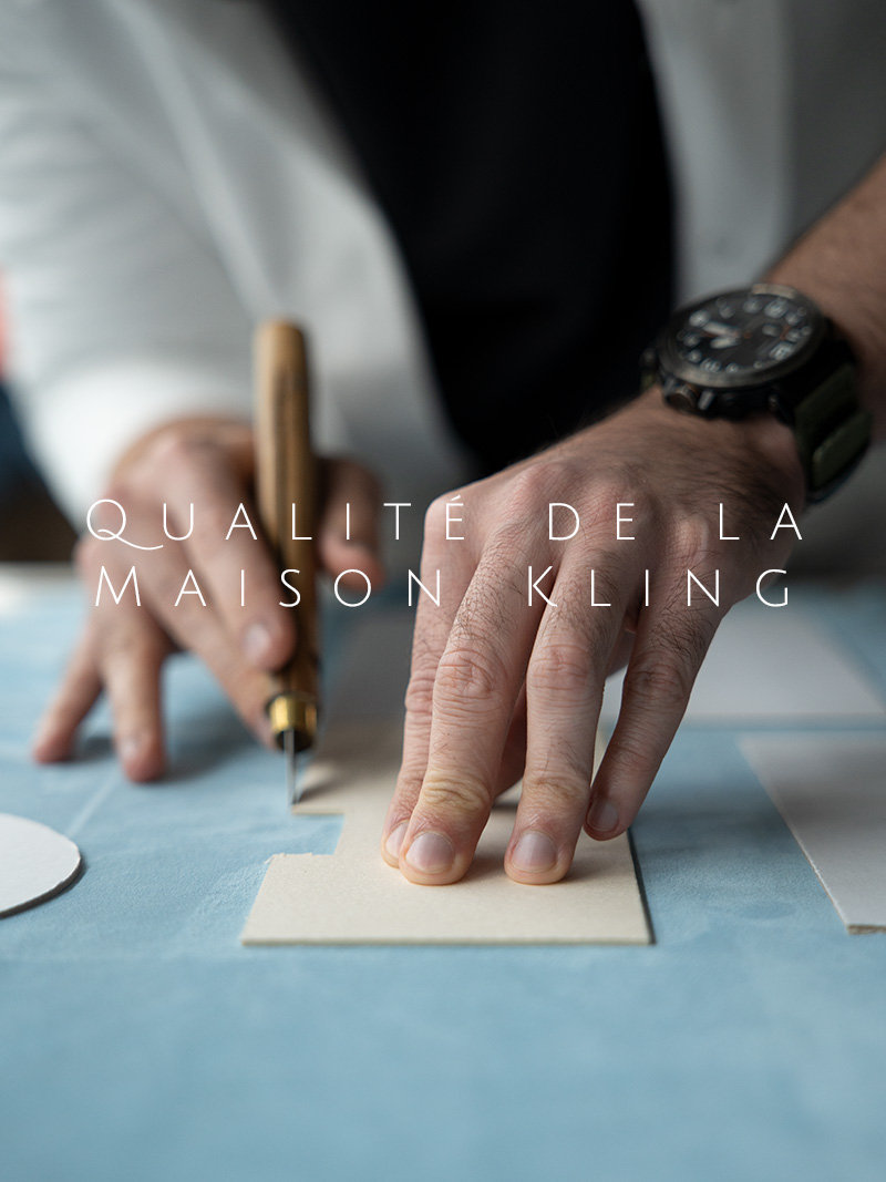 Nahaufnahme auf zwei Hände, die hellblaue Lederstoffe nach Schablonen zuschneiden.